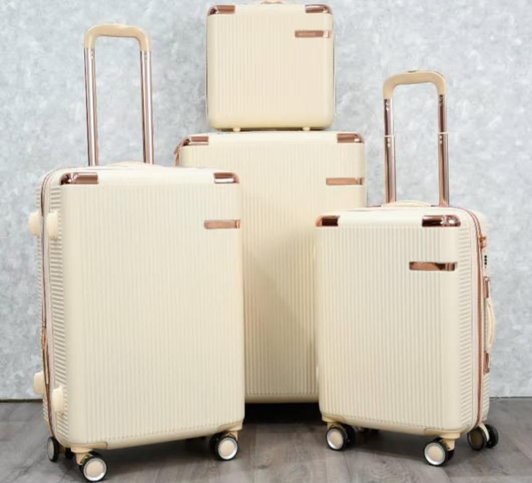 Cream-colored luggage set with copper-colored accents